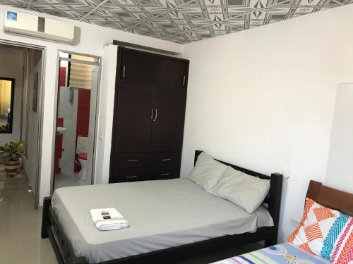 a bedroom with a bed and a black cabinet at Apartamento Iwoo Hr in Villavicencio