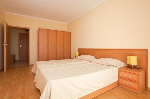 a bedroom with a large bed with a wooden headboard at Apartments in Central Plaza in Sunny Beach