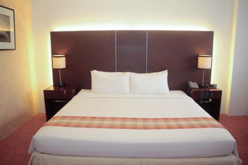 a large bed in a hotel room with two lamps at Casablanca Suites Near Airport in Legazpi