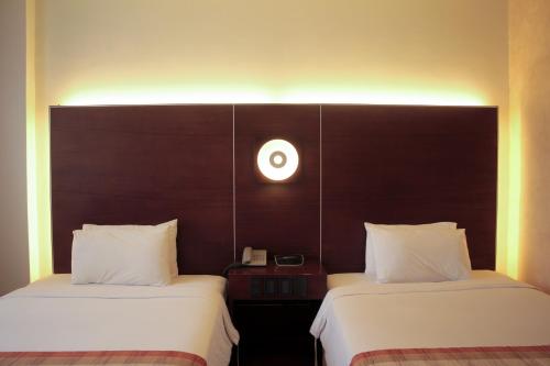 two beds sitting next to each other in a room at Casablanca Suites Near Airport in Legazpi