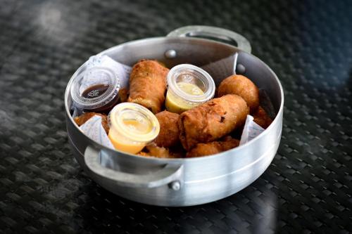 a metal bucket filled with food with dipping sauce at Camping para dos - a escoger, segun disponibilidad de cabaña in Caguas