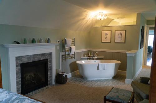 a bathroom with a bath tub and a fireplace at Ravenscroft Inn in Port Townsend