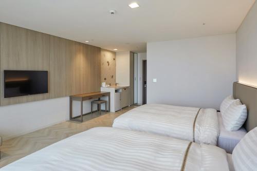a hotel room with two beds and a television at Sol Beach Jindo in Jindo