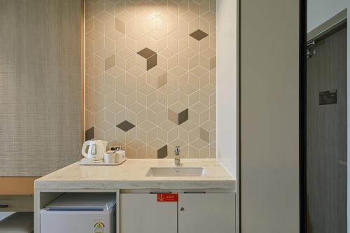 a bathroom with a sink and a tile wall at Sol Beach Jindo in Jindo