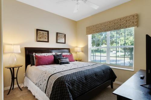 een slaapkamer met een groot bed en een raam bij 5 Bed 4 Bath Town Home With South Facing Pool townhouse in Kissimmee