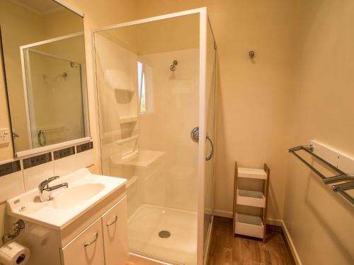 baño blanco con ducha y lavamanos en That View - Kaiteriteri Holiday Home, en Kaiteriteri