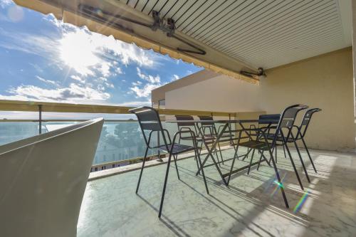 une table et des chaises sur le balcon d'un bâtiment dans l'établissement 4P Apartment with Terrace Sea View and Pool, à Cannes