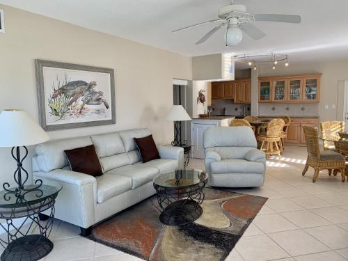 a living room with a couch and chairs and a kitchen at Island House Beach Resor 13N in Point O'Rocks