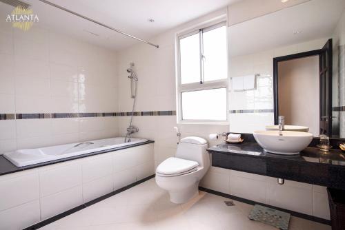 a bathroom with a tub and a toilet and a sink at Atlanta Residences in Hanoi