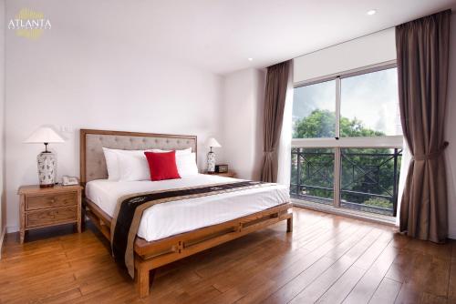 a bedroom with a bed and a large window at Atlanta Residences in Hanoi
