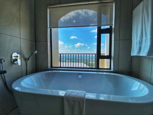 a bath tub in a bathroom with a large window at The Northcliff Boutique Hotel in Johannesburg