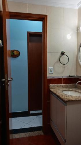 baño con lavabo y puerta marrón en Apartamento praia Grande en São Paulo