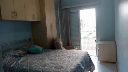 um quarto com uma cama e uma grande janela em Apartamento praia Grande em São Paulo