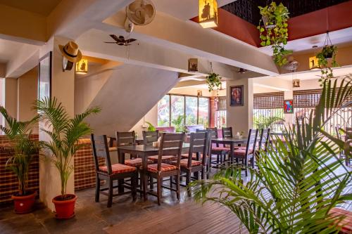 a restaurant with tables and chairs and plants at Resort Martins Siesta by Leela inn , A Portuguese Heritage Resort in Calangute in Arpora