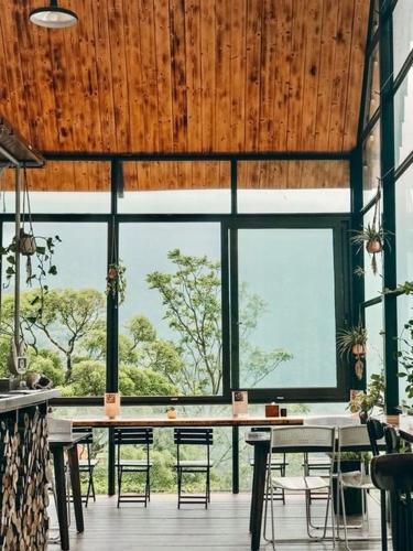 a dining room with a table and chairs and windows at Le vent Tam Đảo homestay in Tam Ðảo