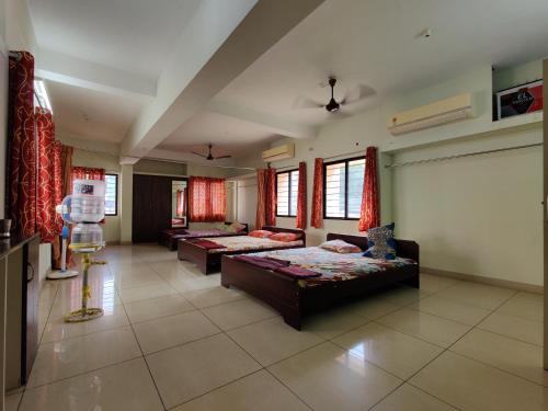 a large living room with two beds and windows at RAK RESIDENCY in Tiruchirappalli
