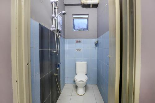 a bathroom with a toilet and blue tiles at SPOT ON 89751 Bed Station Guest House in Tanah Rata