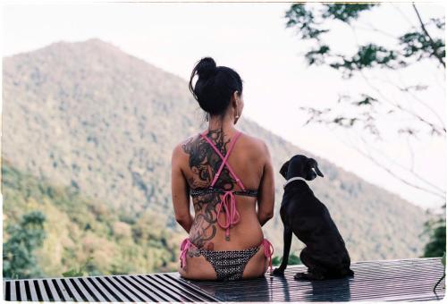 a woman in a bikini sitting on a bench with a dog at Le vent Tam Đảo homestay in Tam Ðảo