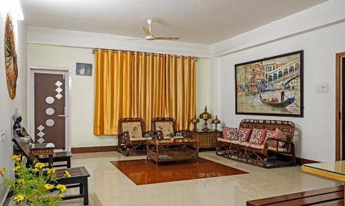 a living room with chairs and a couch and a window at Treebo Umal Homestay Ganeshguri in Guwahati