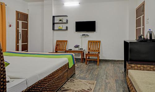 a hotel room with two beds and a television at Treebo Umal Homestay Ganeshguri in Guwahati