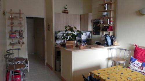 uma cozinha com um balcão e cadeiras num quarto em Appartement Clémenceau em Saint Malo
