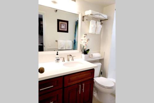 a bathroom with a sink and a toilet and a mirror at Waikiki Marina Studio, Ocean view, Free Parking & Wifi in Honolulu