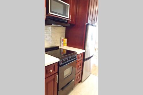 a kitchen with a stove and a tv on the wall at Waikiki Marina Studio, Ocean view, Free Parking & Wifi in Honolulu