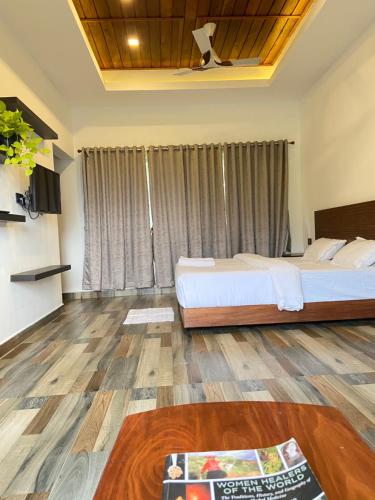 een slaapkamer met 2 bedden en een houten vloer bij Mannoor Farms Mountain View Stays, Munnar in Munnar