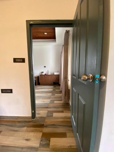 a door leading into a hallway with a floor at Mannoor Farms Mountain View Stays, Munnar in Munnar