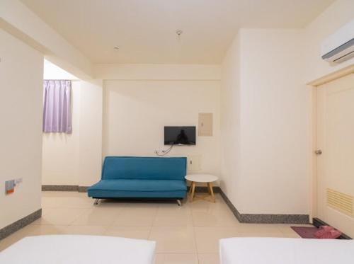金寧鄉的住宿－愛渡假民宿 ，客厅配有蓝色的沙发和桌子
