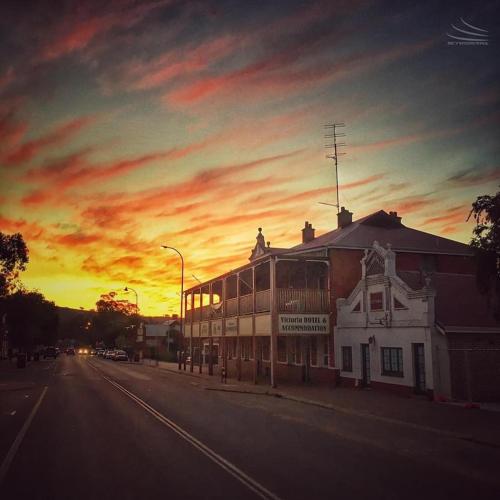 a building on the side of a street with a sunset at Victoria Hotel Toodyay in Toodyay