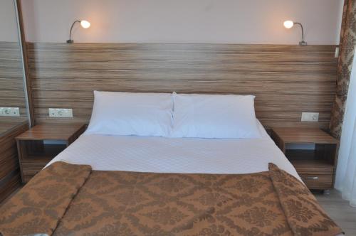 een slaapkamer met een groot bed met een houten hoofdeinde bij Dort Mevsim Suit Hotel in Canakkale