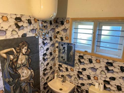 a bathroom with a painting of a woman on the wall at Trippr Chikkamagaluru in Chikmagalūr