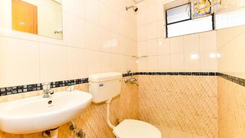 a bathroom with a toilet and a sink at TRI-STAR RESIDENCY Cochin in Ernakulam