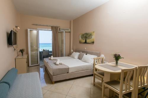 Sala de estar con cama y mesa de comedor en Marilyn Apartments en Rethymno Town