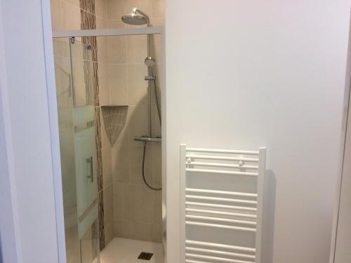 a bathroom with a shower with a glass door at La parenthèse in Saintes