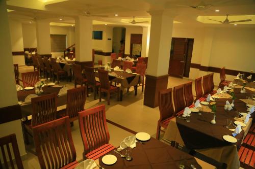 a dining room with tables and chairs and a restaurant at Hotel Victoria International in Kattappana