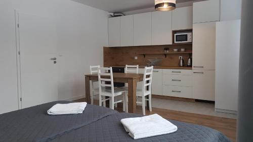 a room with a table and a kitchen with white cabinets at Pensjonat Orle Gniazdo in Jelenia Góra