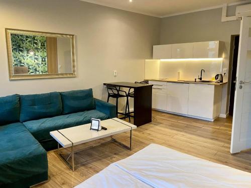un salon avec un canapé et une table et une cuisine dans l'établissement Apartmenty Mariacka 20 -Self Check-In 24h -Loud on the weekends - by Kanclerz Investment, à Katowice