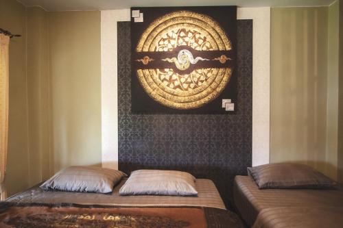 two beds in a room with a picture on the wall at Pai Panalee The Nature Boutique Hotel in Pai