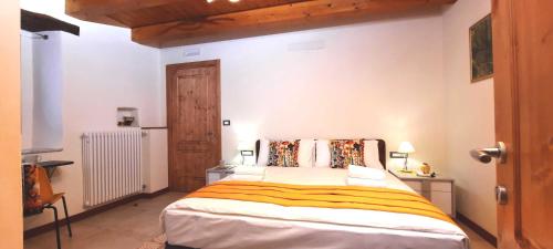 a bedroom with a large bed and a wooden ceiling at Camere B81 di Strain Neva in San Dorligo della Valle