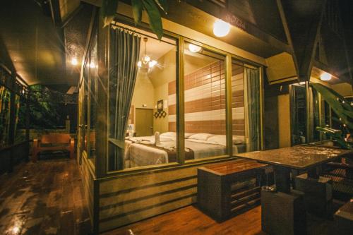 een slaapkamer met een bed en een grote spiegel bij Pai Panalee The Nature Boutique Hotel in Pai