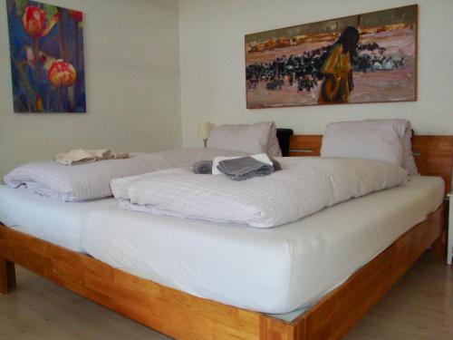 a large white bed in a room with a painting at Casa Almis, Grindelwald in Grindelwald