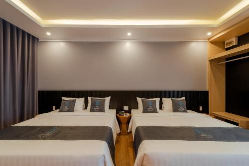 a hotel room with two beds and a wall at The Empire Hotel in Phu Quoc