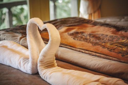 two towel swans sitting on top of a bed at Pai Panalee The Nature Boutique Hotel in Pai