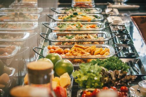 a buffet line with many trays of food at Pai Panalee The Nature Boutique Hotel in Pai