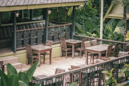 an outdoor patio with wooden tables and chairs at Pai Panalee The Nature Boutique Hotel in Pai