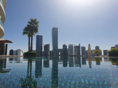 einen Pool mit einer Skyline der Stadt im Hintergrund in der Unterkunft Dubai Downtown View in Dubai