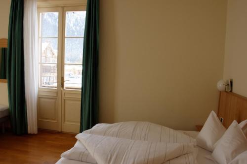 a bedroom with a bed and a large window at Guesthouse - Cultural Center Gustav Mahler in Dobbiaco