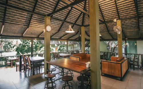 a restaurant with a wooden table and chairs and a clock at Pai Panalee The Nature Boutique Hotel in Pai